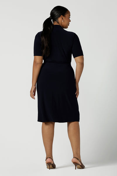 Back view of Kade dress in Navy A size 16 is a functioning wrap dress in navy. Featuring a mandarin collar and short sleeves. Gathered at the waist with a functioning tie. Made in Australia for women size 8 - 24.