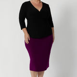 Size 18 woman wears the Kyle top in Black. A soft wrap top made in Australia for women size 8 - 24. The perfect work to weekend top in comfortable and easy care jersey.