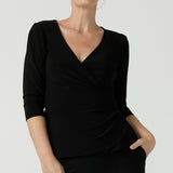 Size 10 woman wears the Kyle top in Black soft jersey. A soft wrap top made in Australia for women size 8 - 24. The perfect work to weekend top in comfortable and easy care jersey. Made in Australia for women size 8 - 24. 