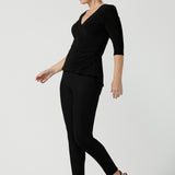 Size 10 woman wears the Kyle top in Black soft jersey. A soft wrap top made in Australia for women size 8 - 24. The perfect work to weekend top in comfortable and easy care jersey. Made in Australia for women size 8 - 24.