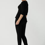 Back view of a size 10 woman wears the Kyle top in Black soft jersey. A soft wrap top made in Australia for women size 8 - 24. The perfect work to weekend top in comfortable and easy care jersey. Made in Australia for women size 8 - 24.