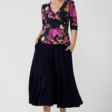 A size 10 woman wears the Celeste Top and Navy Berit Maxi Skirt. A beautiful fixed wrap top with a peplum and shoulder sleeeve tuck with 3/4 sleeves. Made in Australia for women size 8 - 24.