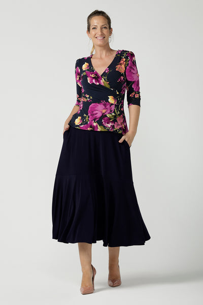 A size 10 woman wears the Celeste Top and Navy Berit Maxi Skirt. A beautiful fixed wrap top with a peplum and shoulder sleeeve tuck with 3/4 sleeves. Made in Australia for women size 8 - 24.