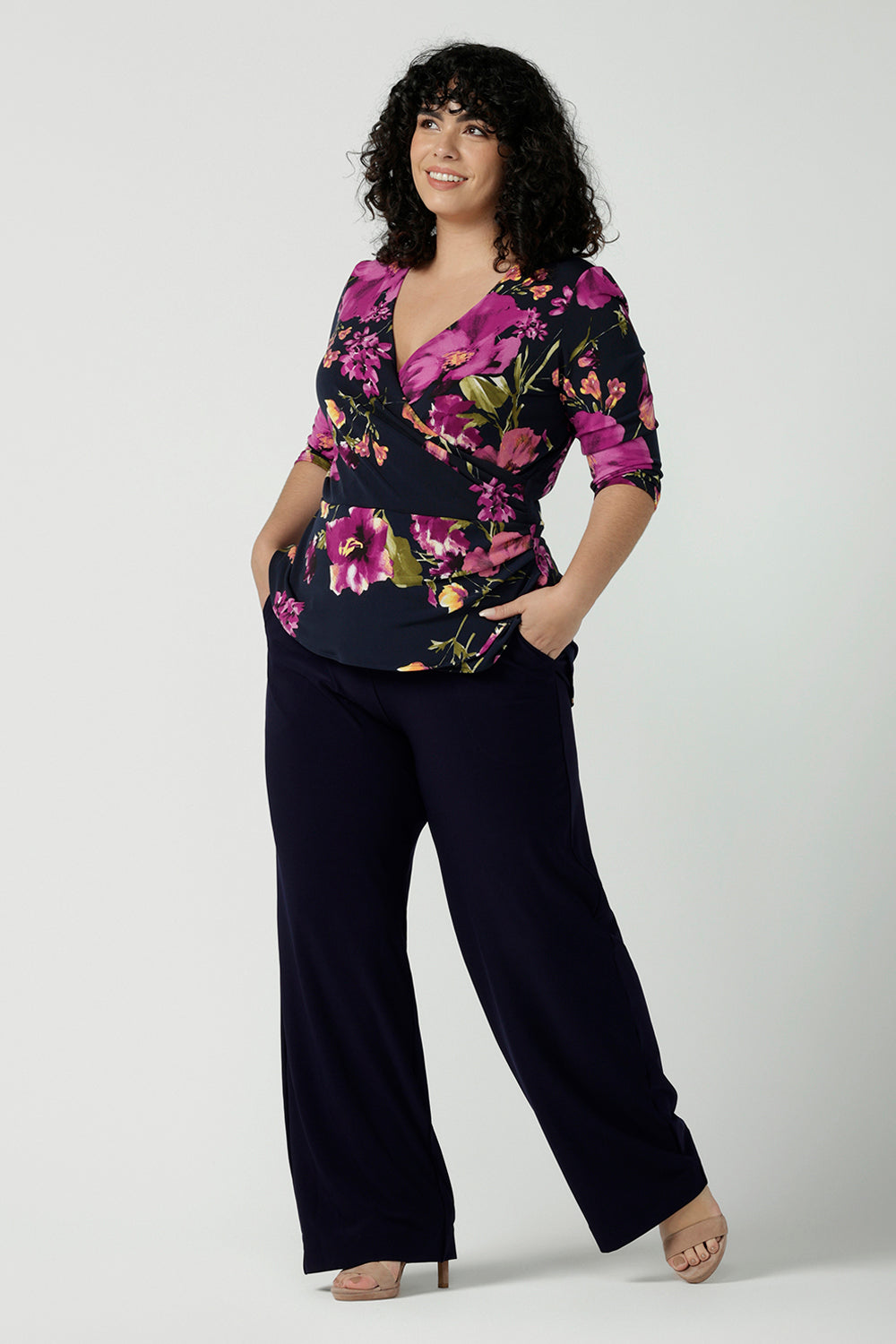 Size 18 woman wears the Celeste Top and Navy monroe pant. A beautiful fixed wrap top with a peplum and shoulder sleeeve tuck with 3/4 sleeves. Made in Australia for women size 8 - 24.