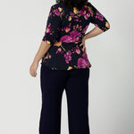 Back view of a size 18 woman wears the Celeste Top and Navy monroe pant. A beautiful fixed wrap top with a peplum and shoulder sleeeve tuck with 3/4 sleeves. Made in Australia for women size 8 - 24.
