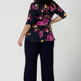 Back view of a size 18 woman wears the Celeste Top and Navy monroe pant. A beautiful fixed wrap top with a peplum and shoulder sleeeve tuck with 3/4 sleeves. Made in Australia for women size 8 - 24.