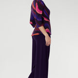 Crafted from our signature dry-touch stretch jersey, the Kyle Top in Jupiter is where bold print meets effortless polish. Featuring a vibrant, colourful swirly pattern. Size 10 model wears her Kyle Top with matching purple pants. 