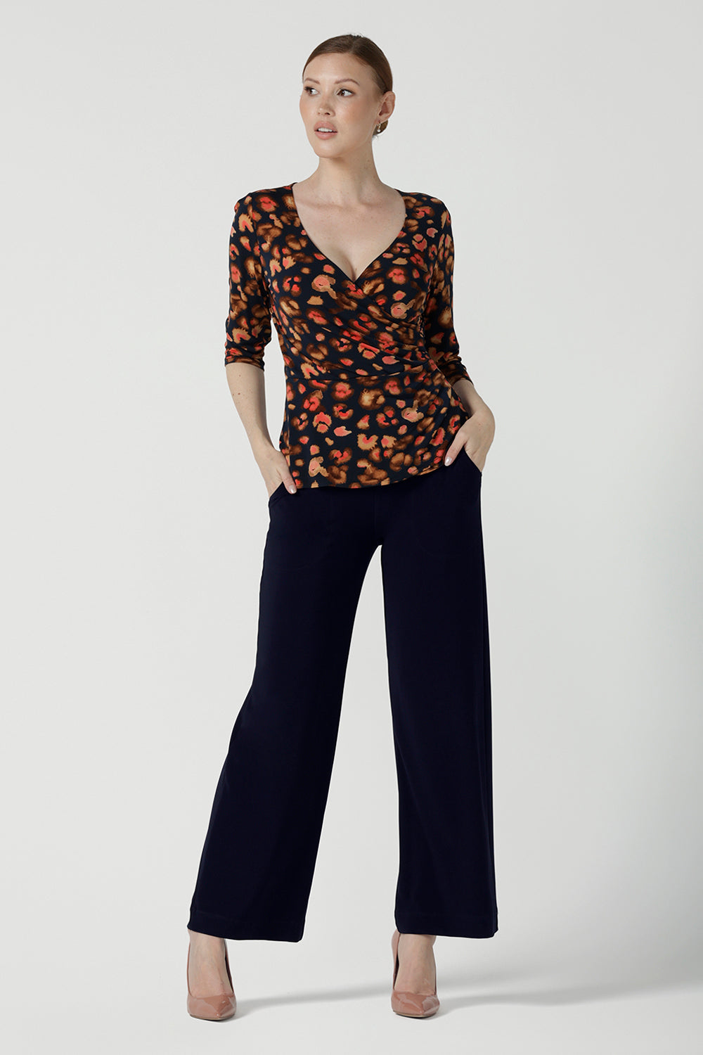 Front view of a Kyle Top in Lava is a functioning wrap to in jersey fabric with animal print. Styled back with Monroe Pant in black. Made in soft jersey fabric and made in Australia for women size 8 - 24.