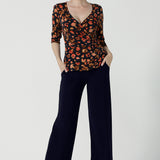 Front view of a Kyle Top in Lava is a functioning wrap to in jersey fabric with animal print. Styled back with Monroe Pant in black. Made in soft jersey fabric and made in Australia for women size 8 - 24.