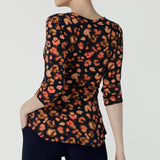 Back view of a Kyle Top in Lava is a functioning wrap to in jersey fabric with animal print. Styled back with Andi midi skirt in leopard print. Made in soft jersey fabric and made in Australia for women size 8 - 24.  Edit alt text