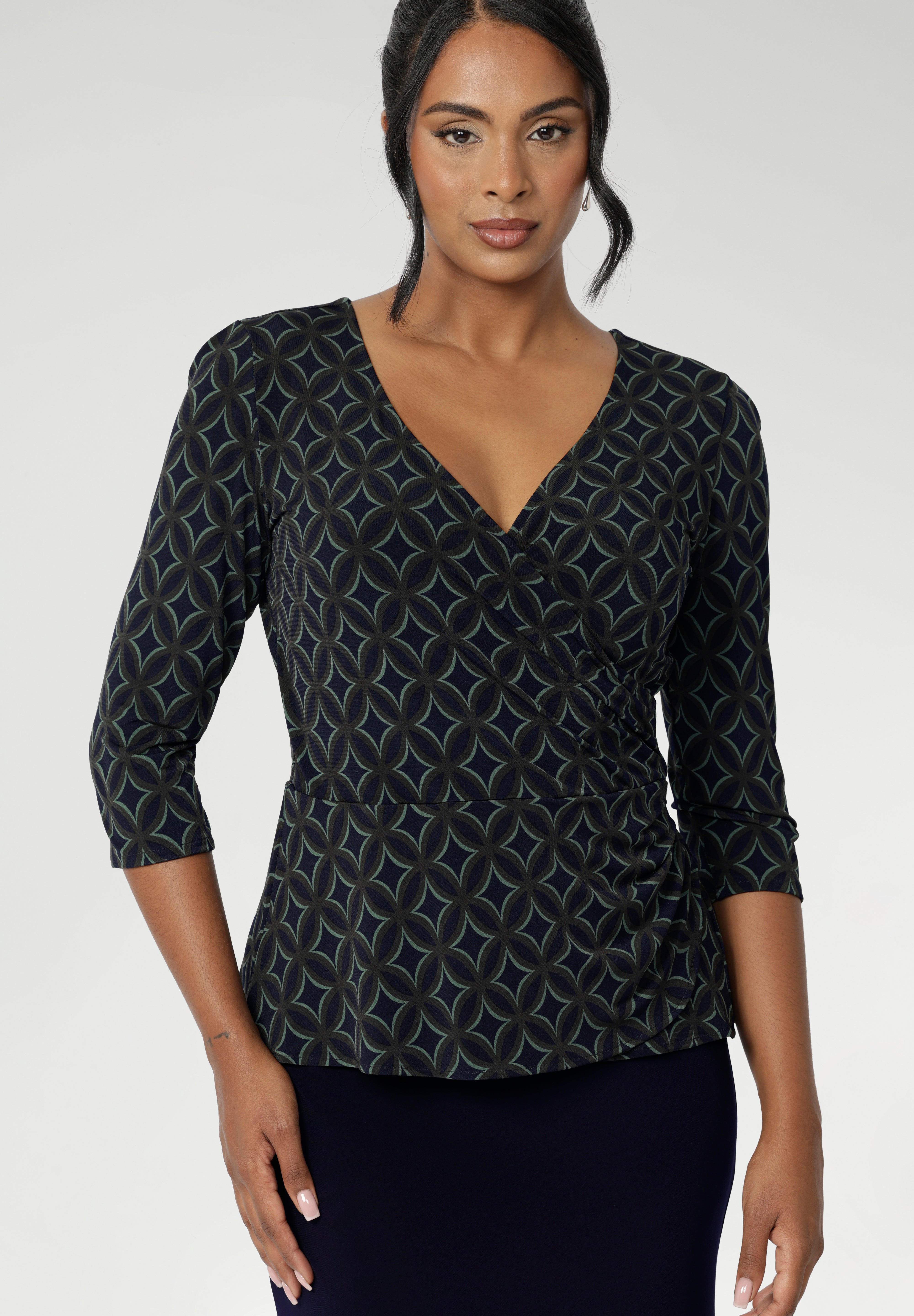 The Kyle Top is the perfect blend of professional style and all-day comfort, designed to keep you looking polished without sacrificing ease. Crafted from a black dry-touch jersey fabric with a soft stretch, this top features a fixed wrap-front bodice that stays perfectly in place, providing a flattering and secure fit. Available in size 8-24. 