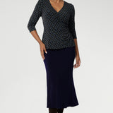 The Kyle Top combines professional sophistication with all-day comfort, crafted for a flawless fit and versatile styling. Made from a navy dry-touch jersey fabric with soft stretch, this top features a fixed wrap-front bodice that stays securely in place, offering a flattering and tailored look. 