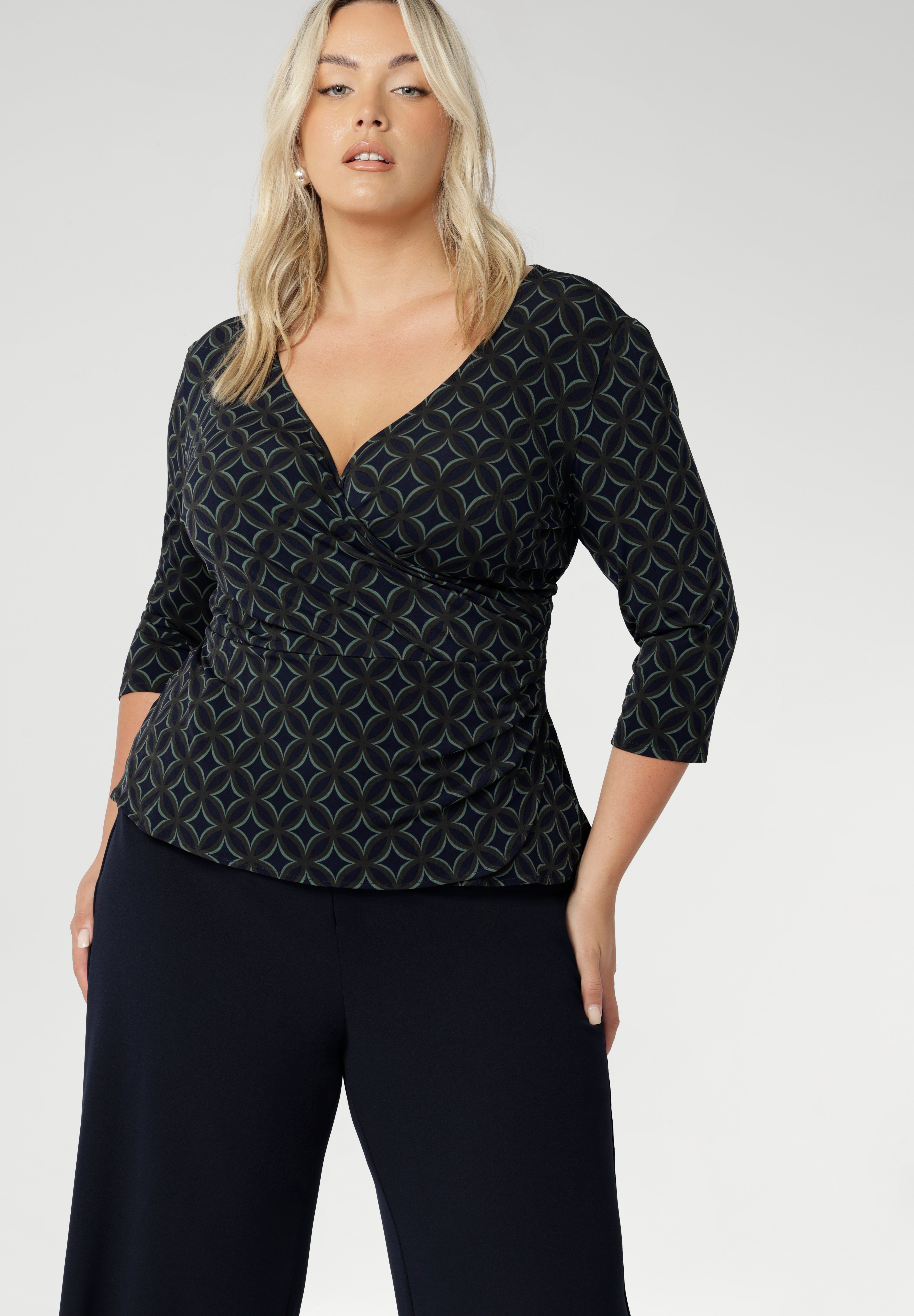 The Kyle Top is the perfect blend of professional style and all-day comfort, designed to keep you looking polished without sacrificing ease. Crafted from a printed dry-touch jersey fabric with a soft stretch, this top features a fixed wrap-front bodice that stays perfectly in place, providing a flattering and secure fit.