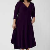 Size 18 Woman wears the Amethyst Kyra dress in jersey. Made in Australia for women. Beautiful twist front neckline with 3/4 sleeve, high-low hem, empire line. Work wear for women and easy care. Great wedding guest outfit, mother of the bride. Made in Australia for women size 8 - 24.