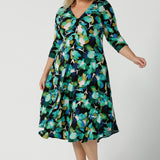 A size 18 woman wears the Kyra dress in Canopy. A twist front dress with a 3/4 sleeve on a watercolour print. Made in Australia for women size 8 - 24. 