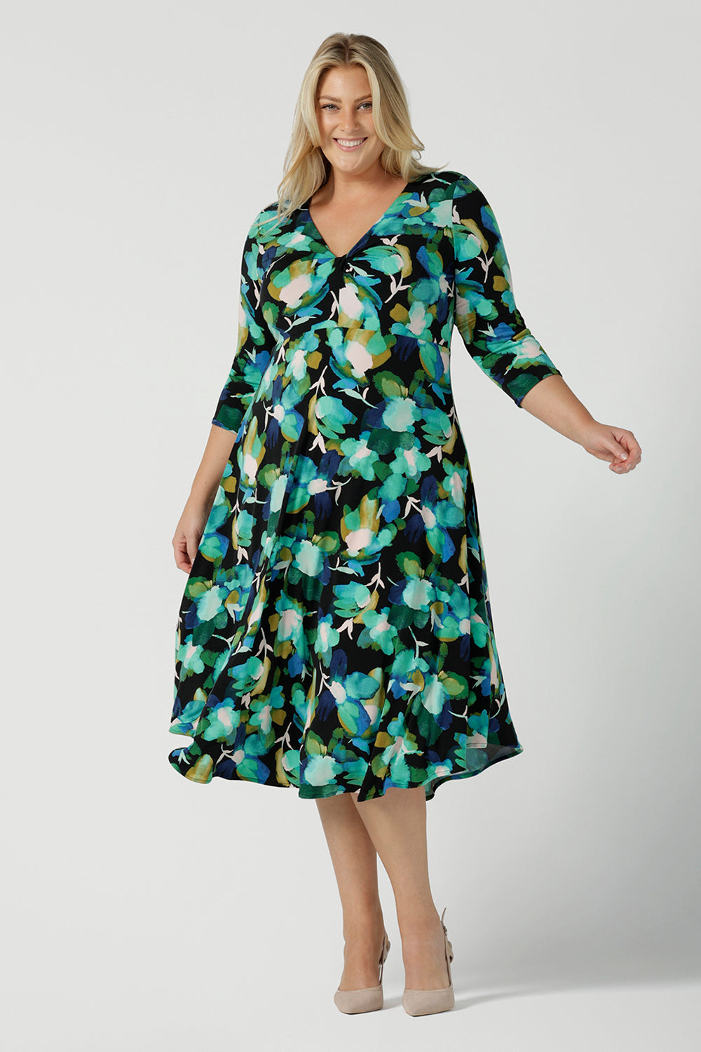 A size 18 woman wears the Kyra dress in Canopy. A twist front dress with a 3/4 sleeve on a watercolour print. Made in Australia for women size 8 - 24. 