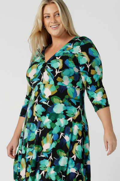 A size 18 woman wears the Kyra dress in Canopy. A twist front dress with a 3/4 sleeve on a watercolour print. Made in Australia for women size 8 - 24.