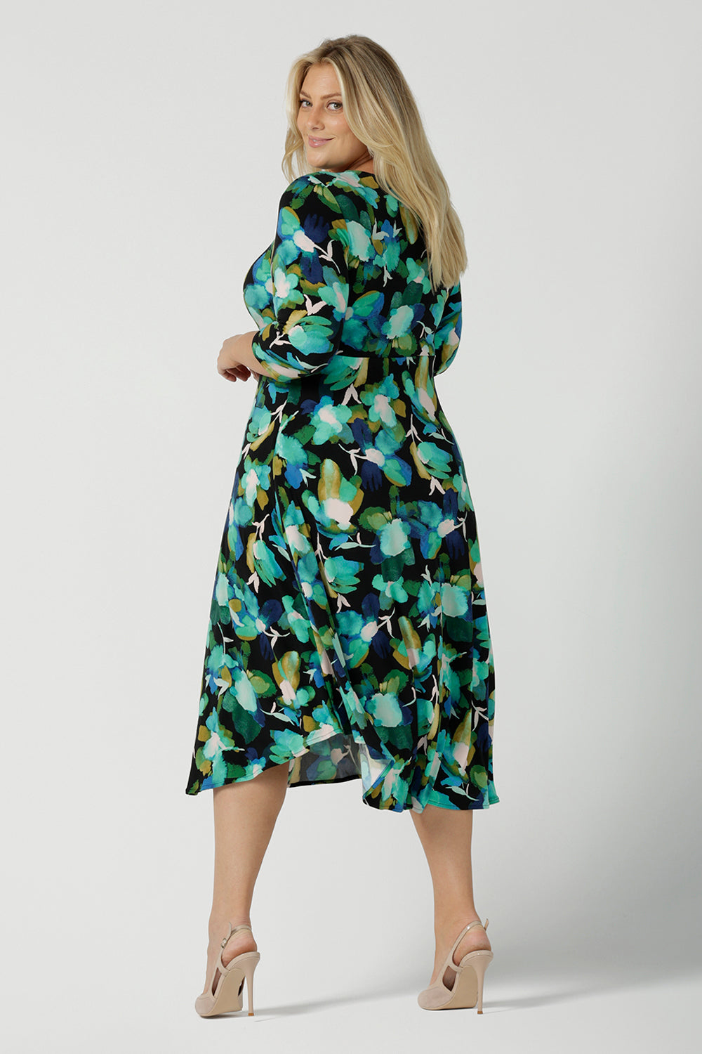 Back view of a size 18 woman wears the Kyra dress in Canopy. A twist front dress with a 3/4 sleeve on a watercolour print. Made in Australia for women size 8 - 24.