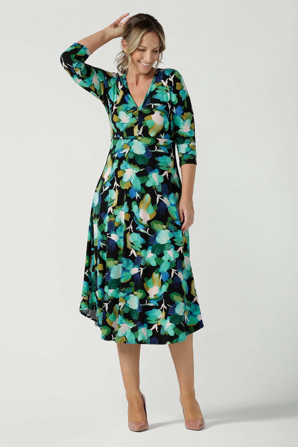 A size 8 woman wears the Kyra dress in Canopy. A twist front dress with a 3/4 sleeve on a watercolour print. Made in Australia for women size 8 - 24.
