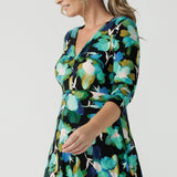 Close up of a size 8 woman wears the Kyra dress in Canopy. A twist front dress with a 3/4 sleeve on a watercolour print. Made in Australia for women size 8 - 24.