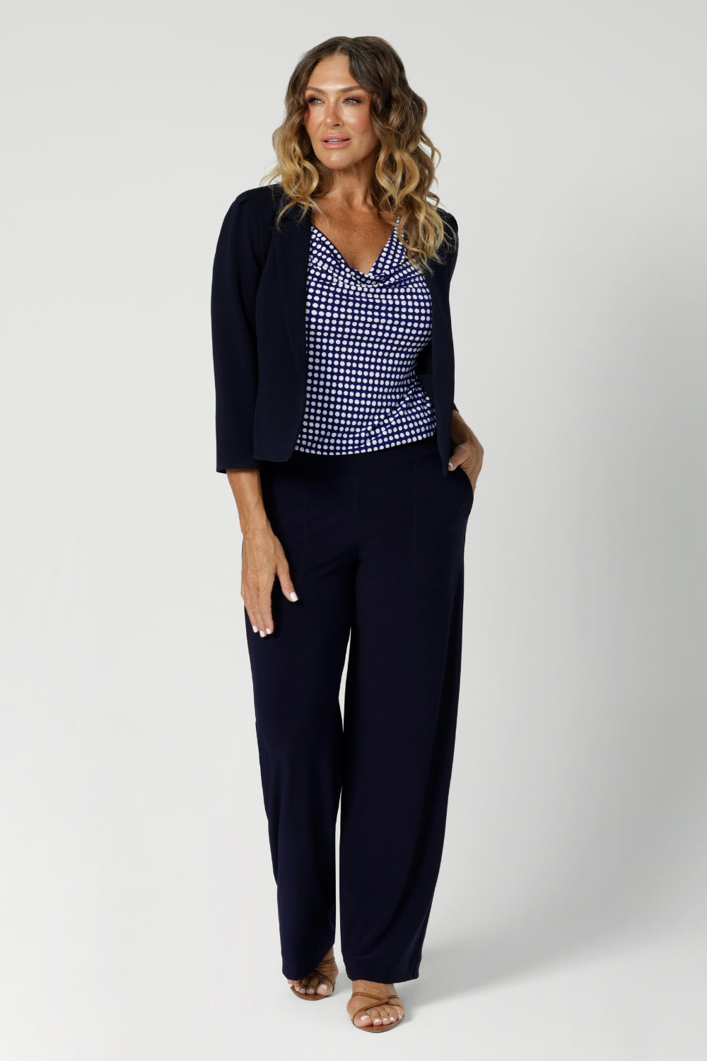 Tailored specifically for the modern woman on the go, this top is an essential addition to any workwear clothing capsule. Size 12 woman wears polka dot printed top with matching navy suiting for an elevated corporate look.