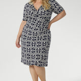 Designed for seamless transitions from the office to evening events and weekend outings, this versatile dress features a flattering fixed wrap bodice, a sophisticated knee-length tulip skirt, and above-elbow sleeves that strike the perfect balance between coverage and style.