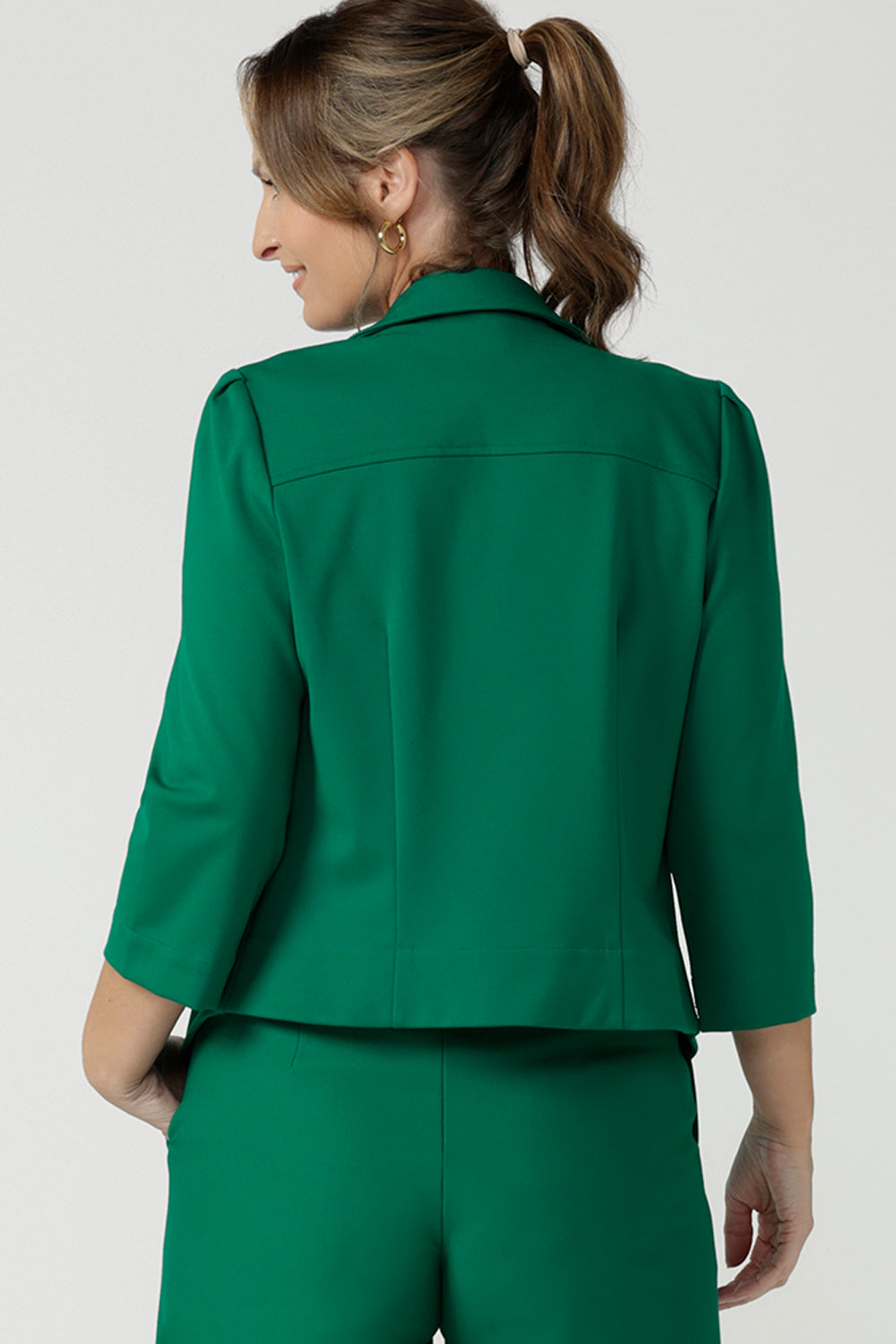 Back view of a size 10 woman wearing a tailored jacket with open front and collar and notch lapels is made in Emerald green ponte fabric. Shop exclusive luxury, this work jacket is available from Australian and New Zealand women's clothing label, L&F.