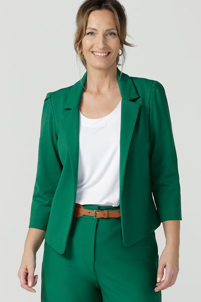 A size 10 woman wearing a tailored jacket with open front and collar and notch lapels is made in Emerald green ponte fabric. Shop exclusive luxury, this work jacket is available from Australian and New Zealand women's clothing label, L&F.