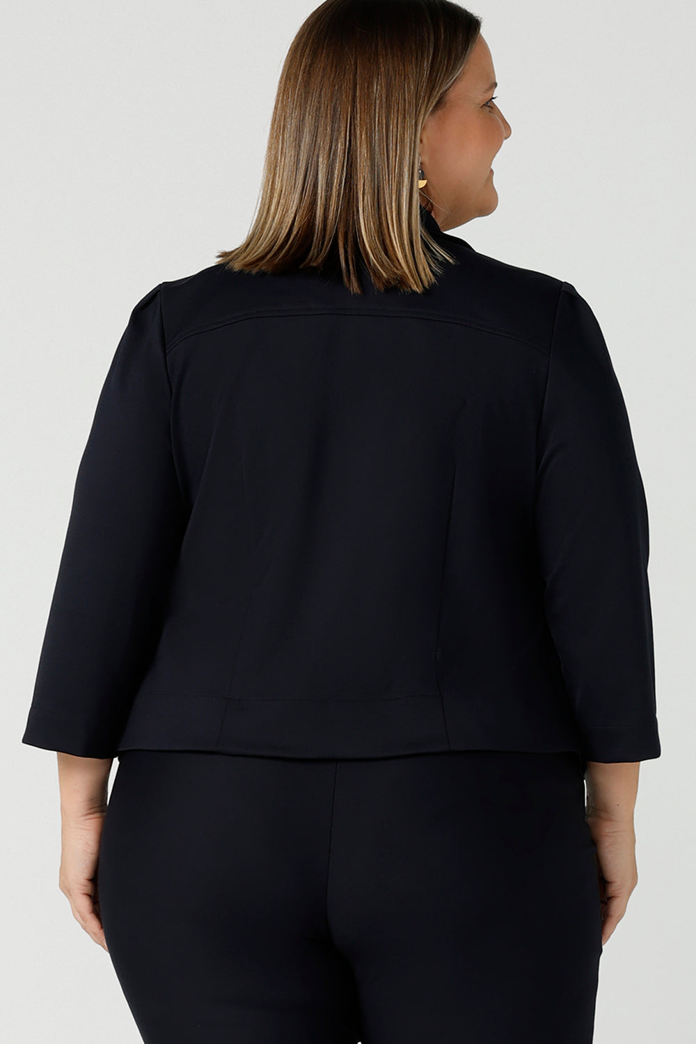 Back view of a curvy size 18 woman wears a tailored navy Lenni Jacket in Ponte. A tailored jacket for work in deep navy. Comfortable workwear for women sizes 8 - 24.