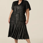 A plus size, size 18 woman wears a good top for curvy women's evening and event wear. In shimmering bronze foil print, this V-neck top with short flutter sleeves is worn with midi length foil print skirt with ruffle hem. Styled together as a faux cocktail dress, both going out top and skirt are made in Australia by women's occasionwear brand, Leina and Fleur.