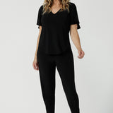 A size 10 woman wears the Lila Top in Black, a jersey workwear top for women for flutter sleeve and v-neckline. Made in Australia for women size 8-24.