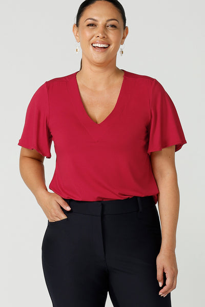 Size 12 curvy woman wears the Lila Top in Flame bamboo in a Christmas red colour. The bamboo material is breathable, soft and temperature regulating. The Lila top features a flutter sleeve and deep v-neckline. Made in Australia for women size 8-24.