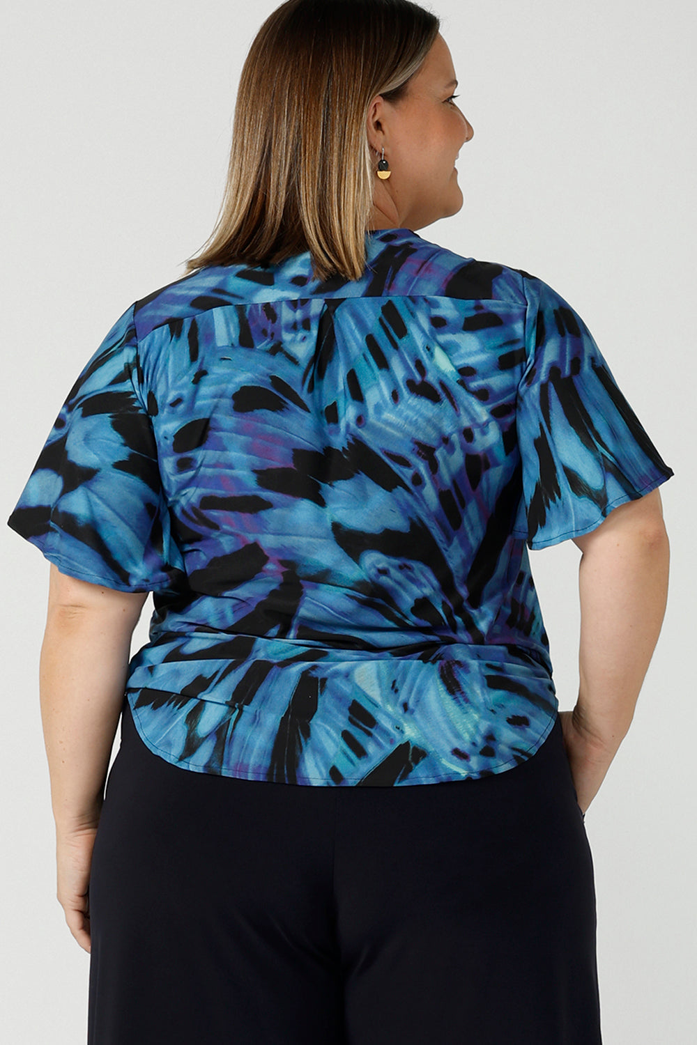 Back view of curvy size 18 woman wears an Lila printed top in Flutter print. Digitally printed with cobalt, purple and black on a butterfly wing abstract print. Made in Australia for women 8 - 24.