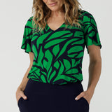 Close up of a size 10 woman wears the Lila Top in Green Jungle. Made in Australia style for women size 8-24. Comfortable jersey fabric and easy care. Flutter sleeve with V-Neckline.