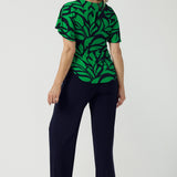 Back view of a size 10 woman wears the Lila Top in Green Jungle. Made in Australia style for women size 8-24. Comfortable jersey fabric and easy care. Flutter sleeve with V-Neckline.