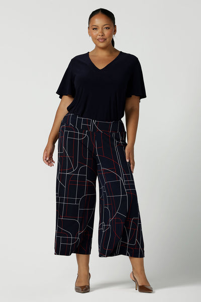A size 16 woman wears the Dany Culotte in Navy Abstract. Corporate comfortable pant for women, geometric print with navy, red and white. Made in Australia for women size 8 - 24.