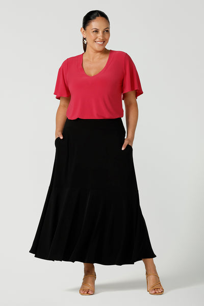 Curvy woman wears Lila flutter sleeve top with v-neckline. Styled back with a black tiered maxi skirt. A comfortable statement piece from the office to the weekend. Designed and made in Australia for women size 8 - 24.