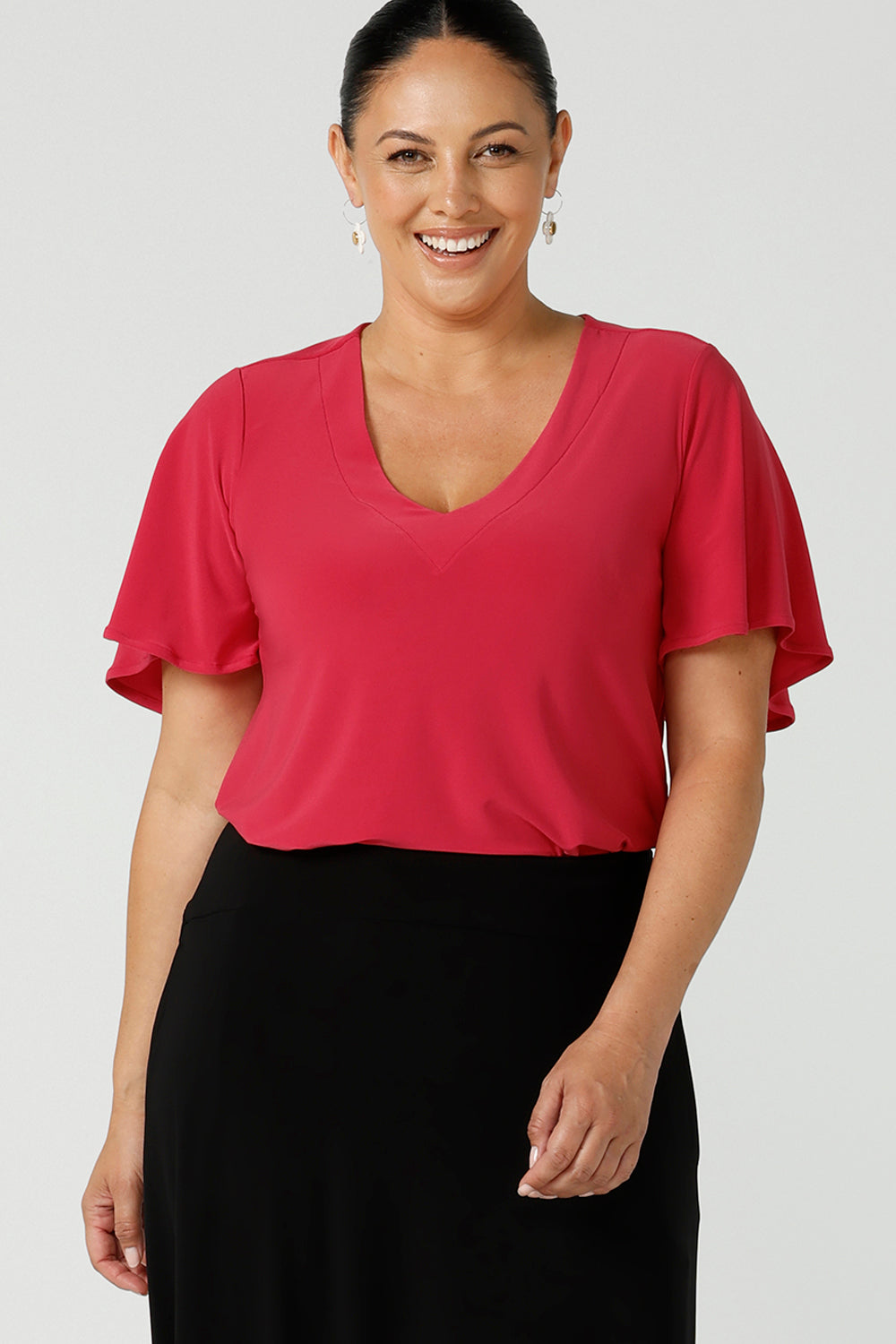 Curvy woman wears Lila flutter sleeve top with v-neckline. A comfortable statement piece from the office to the weekend. Designed and made in Australia for women size 8 - 24. 