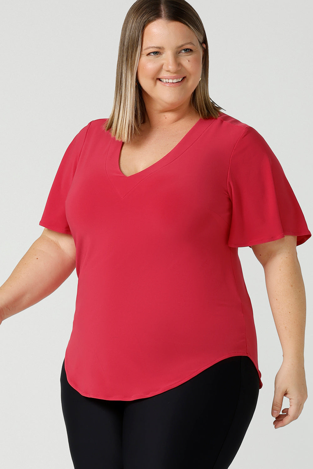  Curvy woman wears Lila flutter sleeve top with v-neckline. A comfortable statement piece from the office to the weekend. Designed and made in Australia for women size 8 - 24.