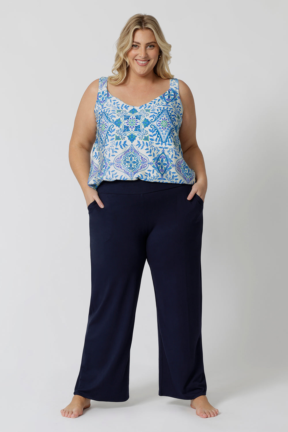 Showing good lounge pants for curvy women, a size 18 wears straight, wide leg navy blue, plus size lounge pants in bamboo jersey with a blue and white print modal cami top. Breathable and thermo-regulating this is a good pyjama set  for night sweats and hot flushes. Stay cool this summer nights with breathable sleepwear by L&F Australia.