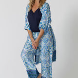 An over 40s woman wears blue and white print pyjama set and dressing gown in size 12. Some of the best pyjamas for menopause, these womens pajamas are made in bamboo jersey and modal, both breathable and thermo-regulating, they are best cooling materials for night sweats. Shop dressing gowns and pyjama sets for women online in sizes 8 to 24.