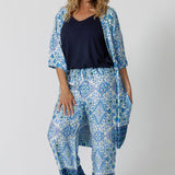 Showing a pretty pyjama set that's great for over 40s women. A size 12 woman wears straight leg pyjama pants with blue and white print with a navy blue bamboo jersey cami top and blue and white pritn lounge robe.  Thermo-regulating and breathable, these lounge pants with drawstring ties are good pyjamas for night sweats and hot flushes. Shop the loungewear set online at L&F Australia in sizes 8 to 24.