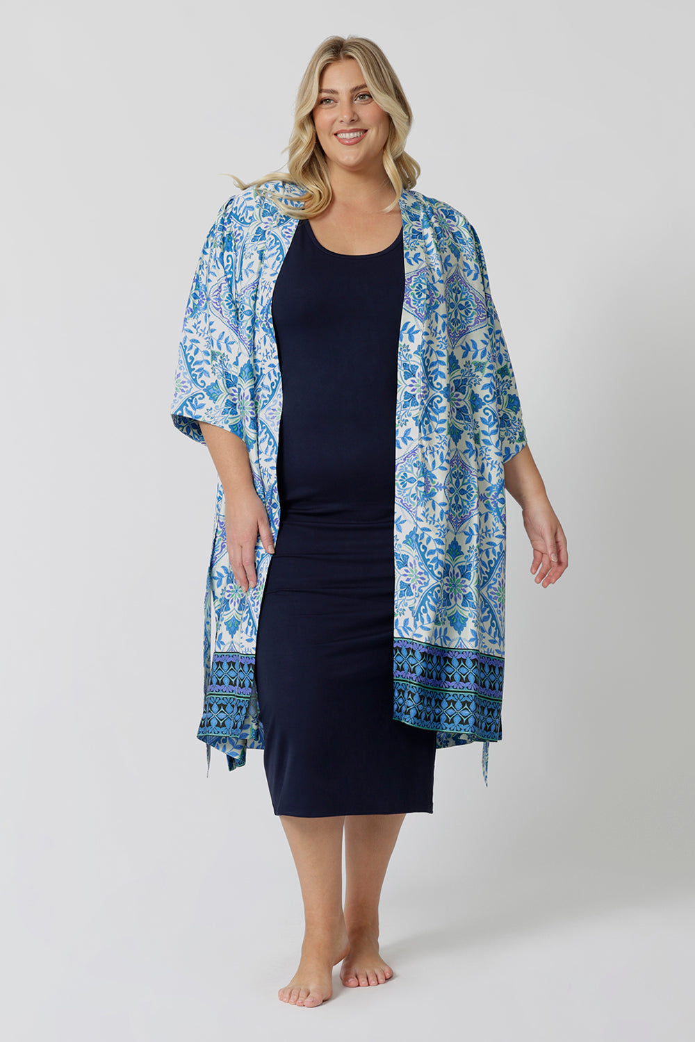 Worn with a blue and white print women's dressing gown , this navy blue lounge dress works as a nightdress and as loungewear. Shown on a size 18 woman, this slim-fit, plus size midi-dress in navy blue bamboo jersey is breathable and thermo-regulating. A good dress for night sweats and hot flushes, wear this as a summer dress for warm summer days. Shop nightdresses in women's clothes brand, L&F's new loungewear and sleepwear range online in sizes 8 to 24.