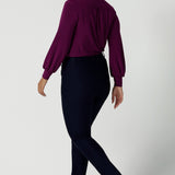 Back view of Lulu tailored pant in Navy. Made in Australia for women. Made in Australia for women size 8 - 24. A tailored pant in Navy with waistband and fly front with pockets. Styled back with the Avery top in Magenta. Proudly made in Australia.