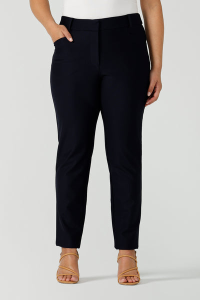 Close up of a curvy size 12 woman wears Lulu cigarette pants in navy ponte. A comfortable tailored work pant with fly front and belt loops. Made in Australia size 8-24.