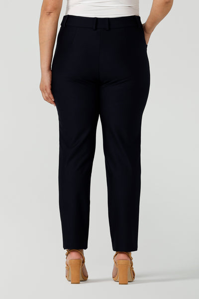 Back view of a size 12 woman wears Lulu cigarette pants in navy ponte. A comfortable tailored work pant with fly front and belt loops. Made in Australia size 8-24.