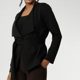 The Lyndon Jacket in Black features a stylish double-layer design with angled front panels for a sleek, modern look. It comes with a detachable waist tie and belt loops, so you can wear it open or cinched to flatter your silhouette. 