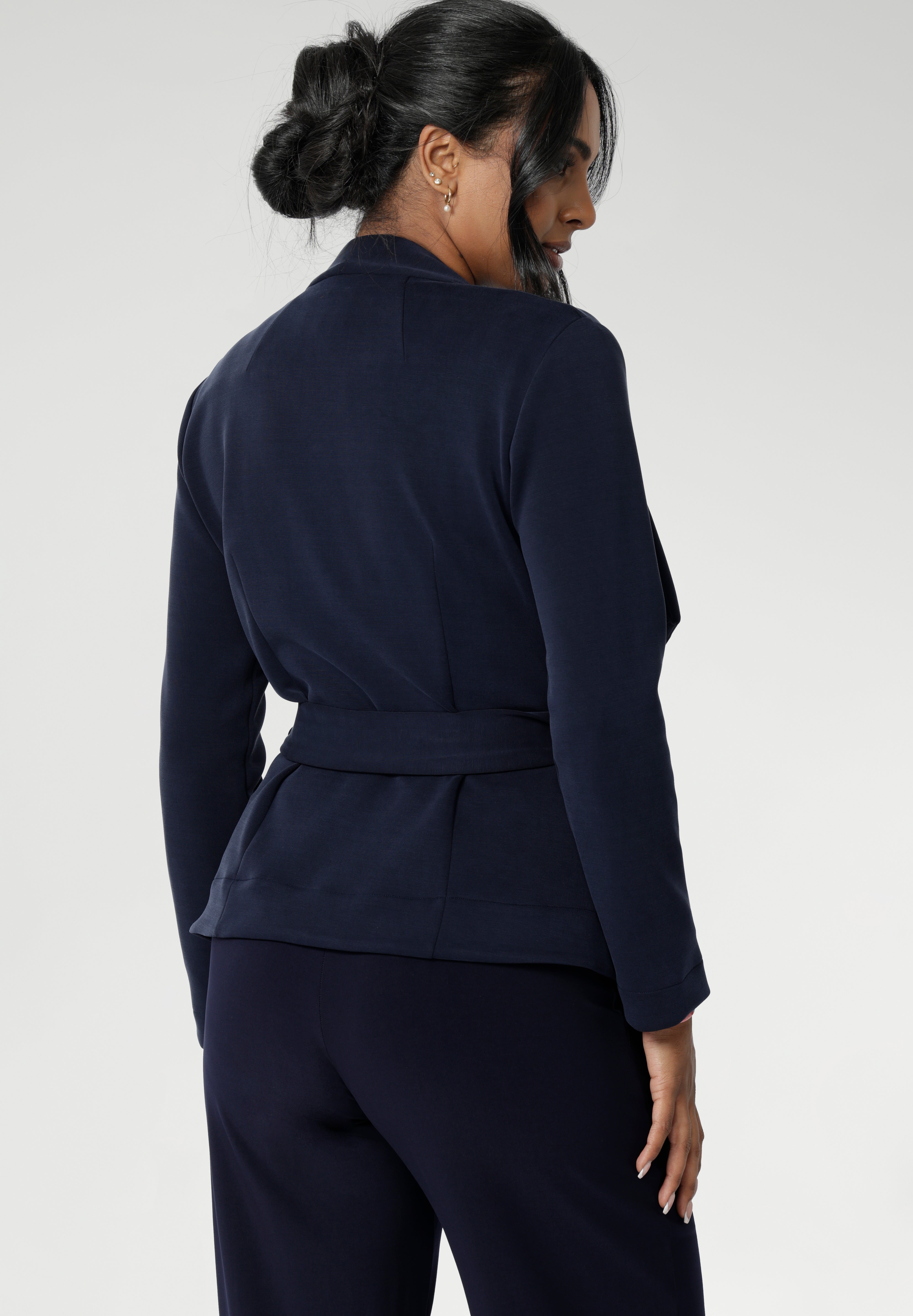 Lyndon features a double-layer jacket with   angled front panels for a modern edge and a detachable waist tie with belt loops, allowing you to wear it open or cinched to define your silhouette. Available in size 8-24