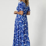 The A-line skirt flows effortlessly to maxi length, creating an elegant, flattering silhouette. Size 12 model pairs maxi dress with high silver high heels & silver jewellery, complimenting the blue hues in the dress. 