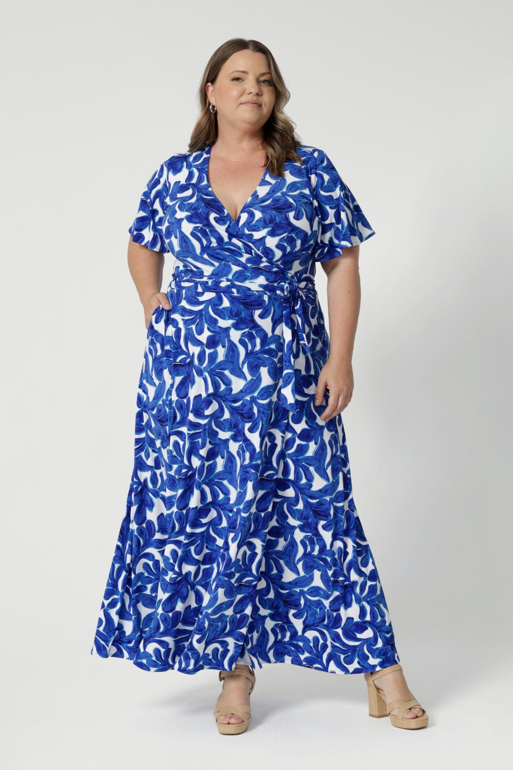 Plus sized model wears maxi dress featuring side pockets to add a casual yet functional element, making this dress as comfortable as it is chic. Available in sizes 8-24 